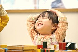 木製の知能教材で遊ぶ2歳児