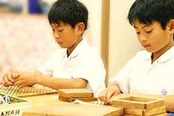 木製教材で考える算数に取り組む小学生