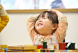 笑顔で積み木に取り組む子ども